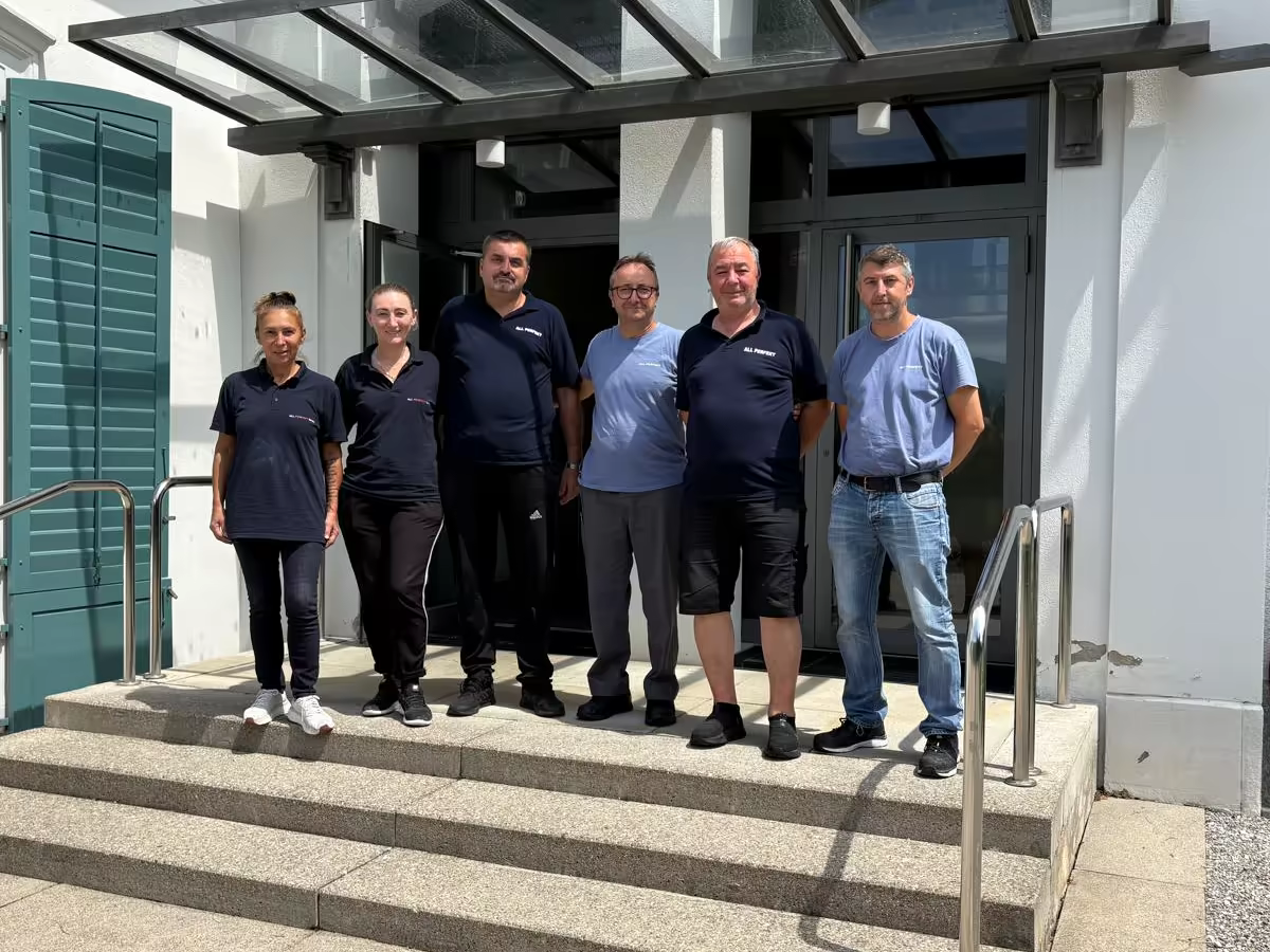Das Team von ALL PERFEKT vor einem betreuten Gebäude